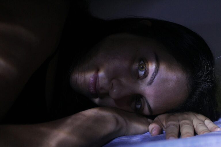 A captivating portrait of a woman lying down, highlighted by dramatic light and shadow effects.